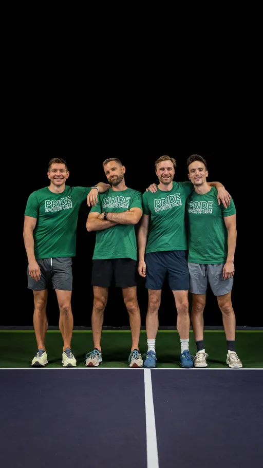 Four pickleball players stand side by side on a court, each wearing matching green "Pride Pickleball Summer 2025" shirts, shorts, and athletic shoes, with their arms around each other, smiling and posing for the photo.